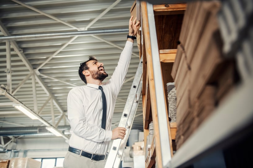 man reaching box on ladder